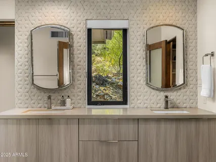 a bathroom with 2 sink and a mirror