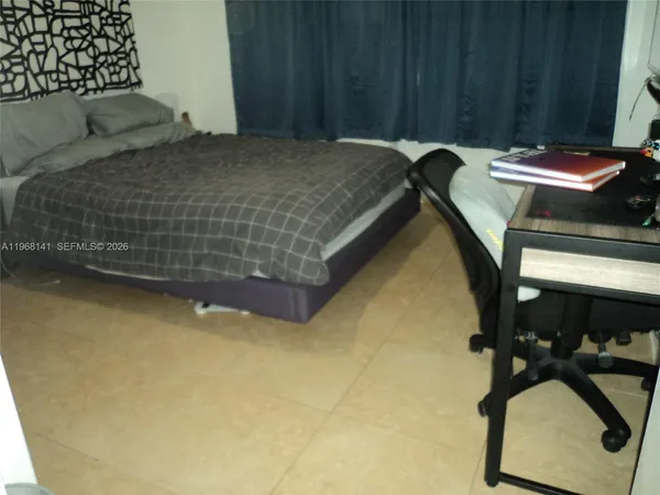 a bedroom with a bed and teddy bear on bed
