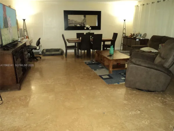 a living room with furniture a flat screen tv and a dining table