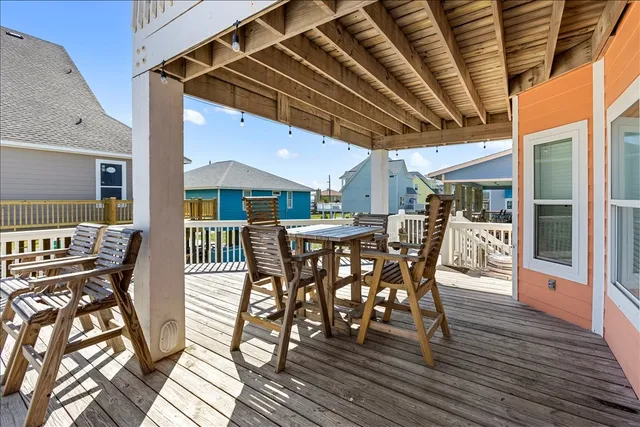 a view of a patio with table and chairs with wooden floor and fence