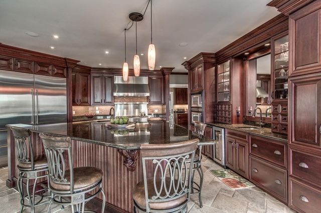 a kitchen with stainless steel appliances a dining table and chairs