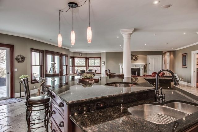 a kitchen with stainless steel appliances granite countertop a sink a stove and a table