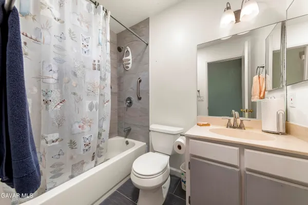 a bathroom with a sink toilet vanity granite shower and bathtub
