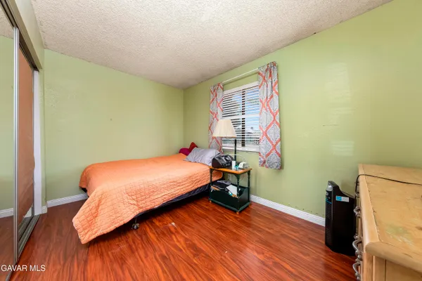 a bedroom with a bed and wooden floor