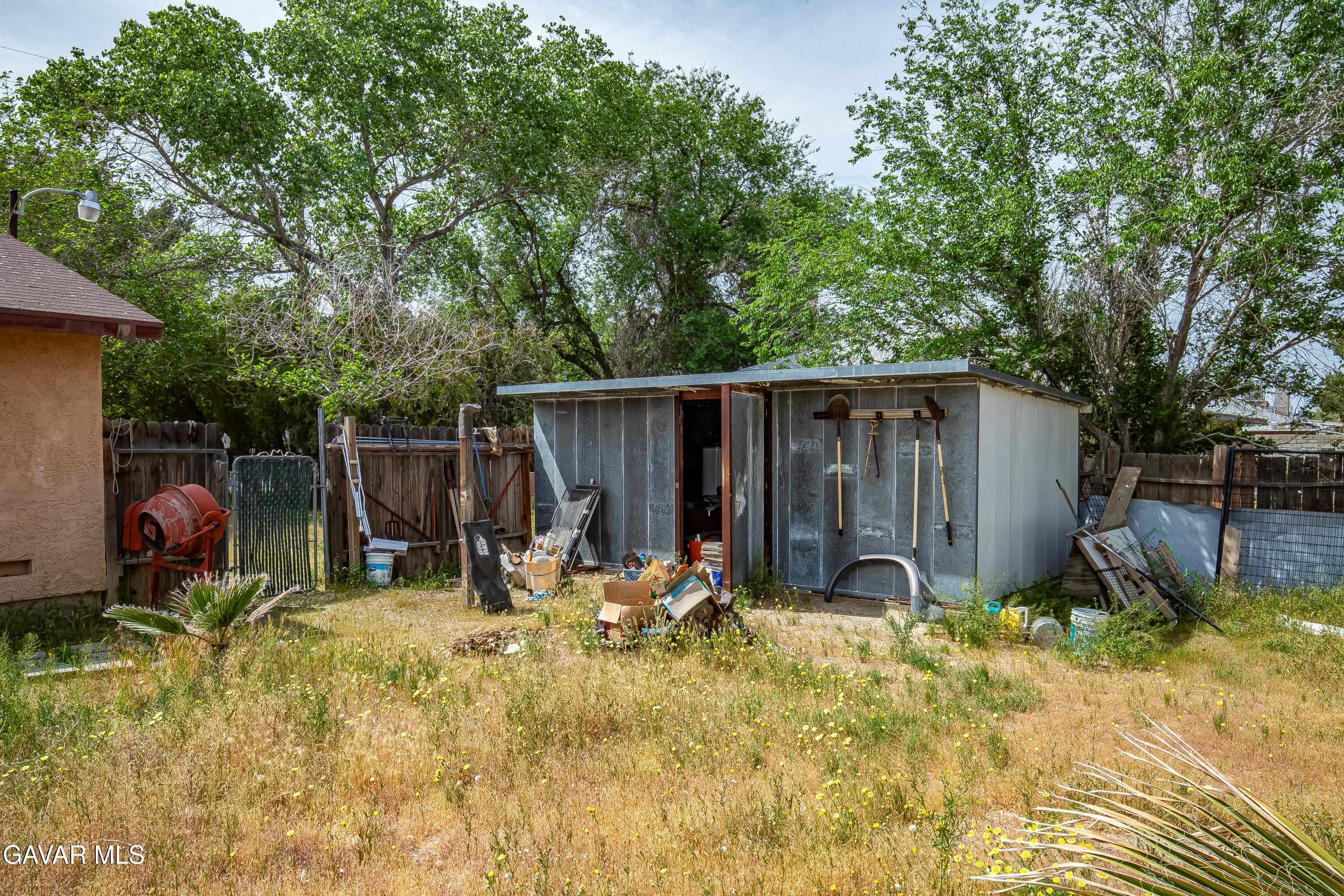 10731 East Ave R-2 Littlerock, CA 93543 - Photo 16 of 23 a view of backyard with wooden fence and a large tree