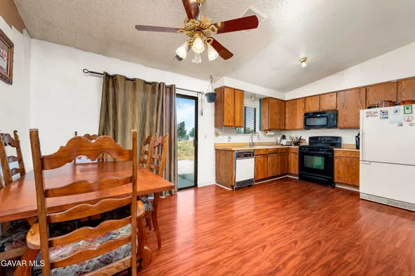 a kitchen with stainless steel appliances a stove a sink a refrigerator cabinets and wooden floor