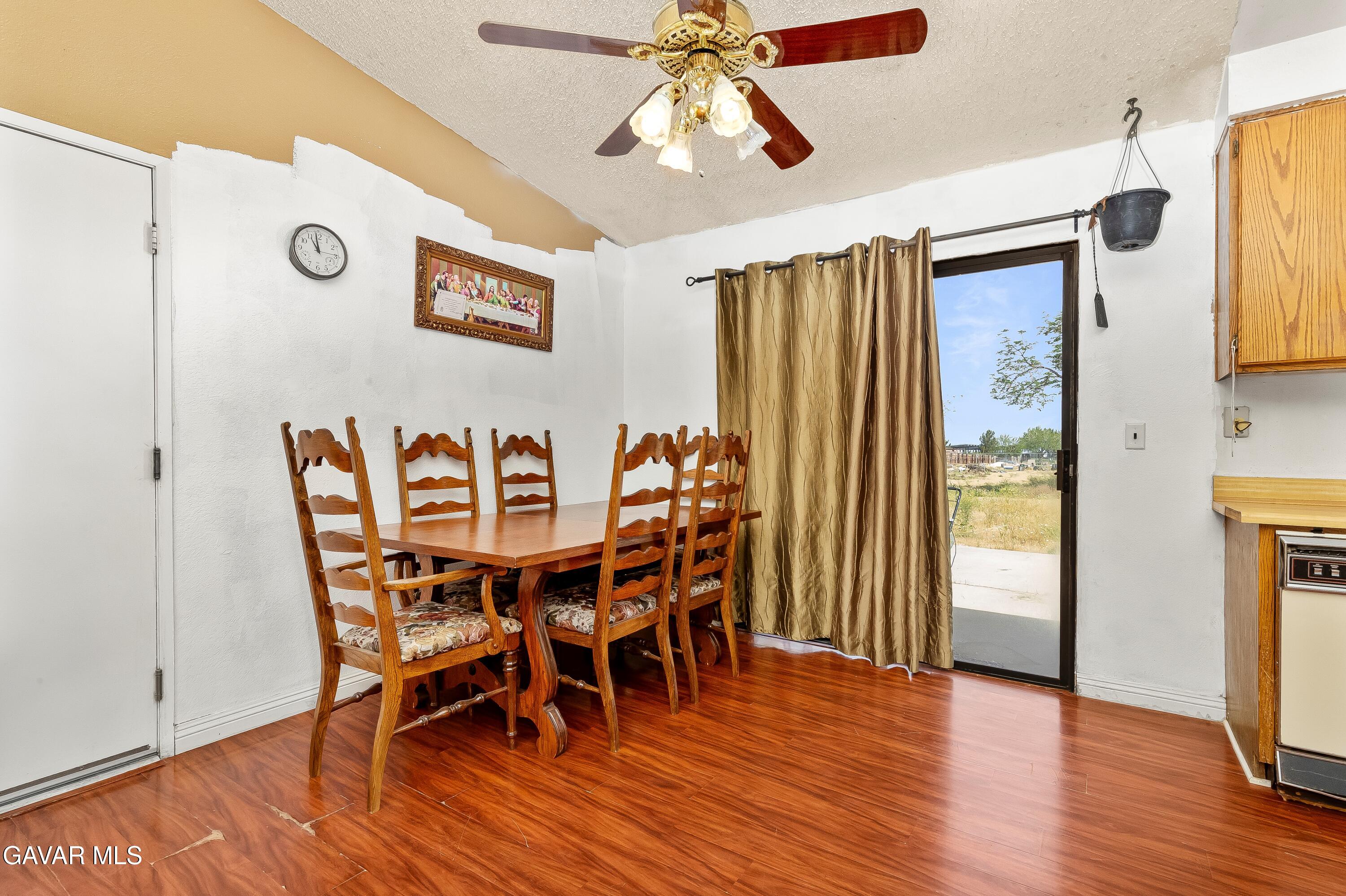 10731 East Ave R-2 Littlerock, CA 93543 - Photo 8 of 23 a dining room with furniture wooden floor a rug and a chandelier