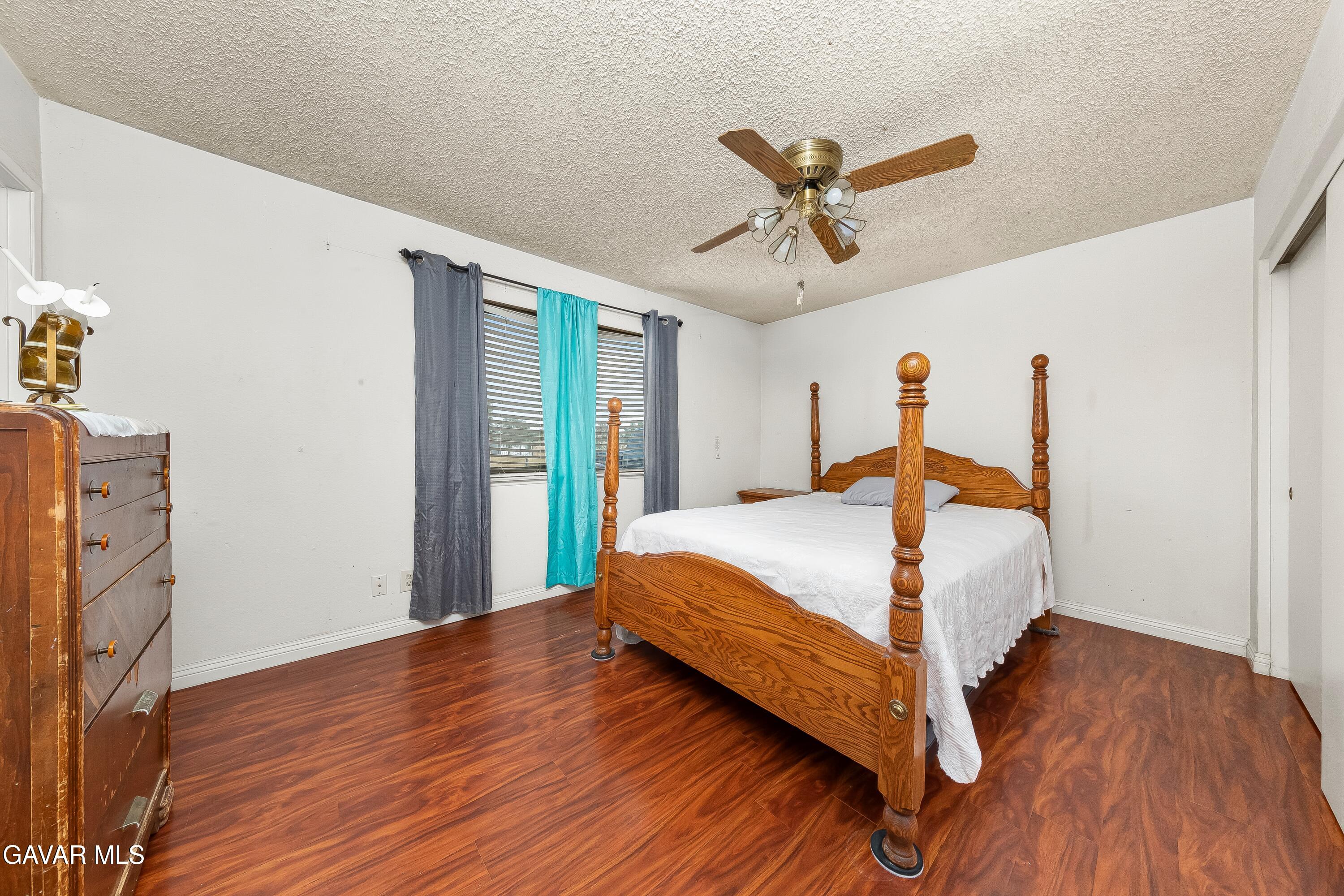 10731 East Ave R-2 Littlerock, CA 93543 - Photo 9 of 23 a bedroom with a bed and wooden floor