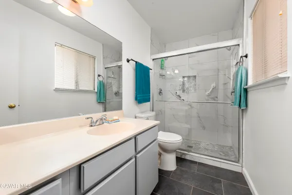 a bathroom with a sink a toilet and shower