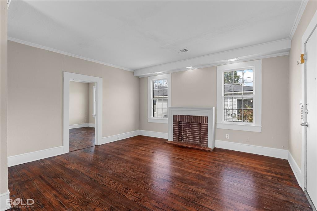323 Butler Road Belcher, LA 71004 - Photo 6 of 28 a view of an empty room with wooden floor fireplace and a window