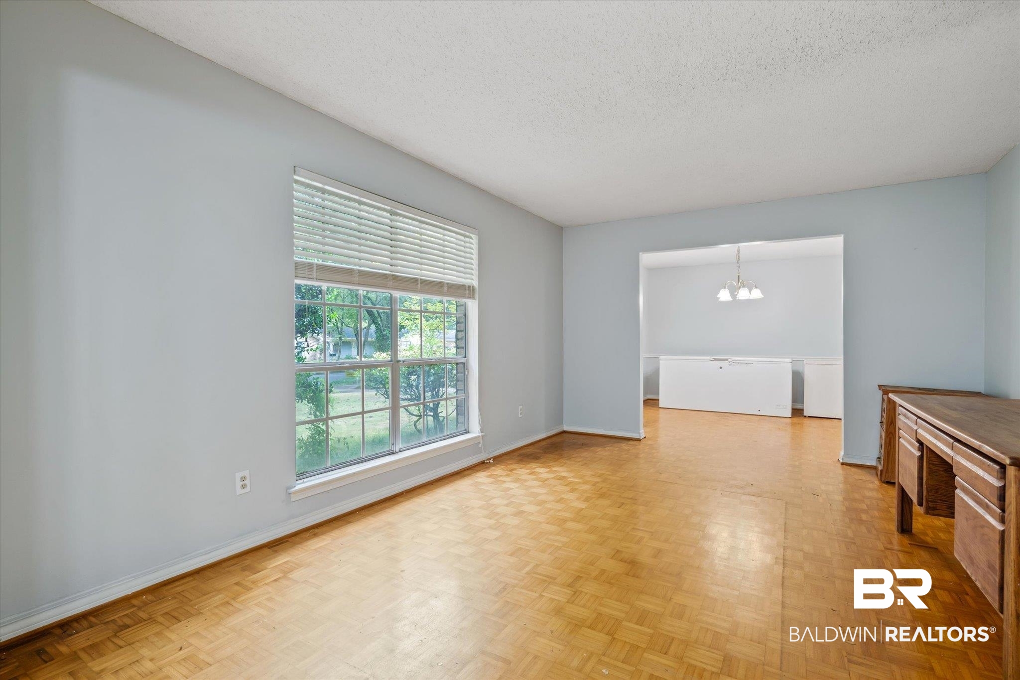 6657 Hounds Run South Mobile, AL 36608 - Photo 3 of 20 Unfurnished living room featuring a textured ceiling, a chandelier, and light parquet flooring