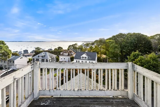 a view of a balcony with wooden floor and outdoor seating