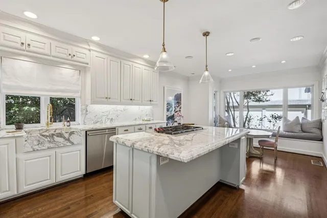 a kitchen with white cabinets stove and wooden floor