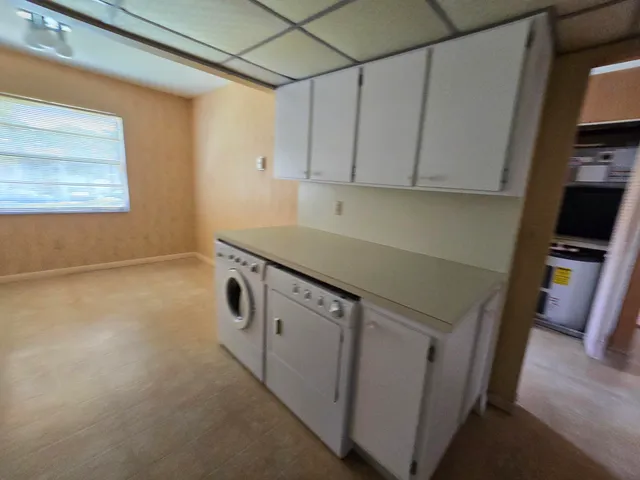 a utility room with cabinets washer and dryer