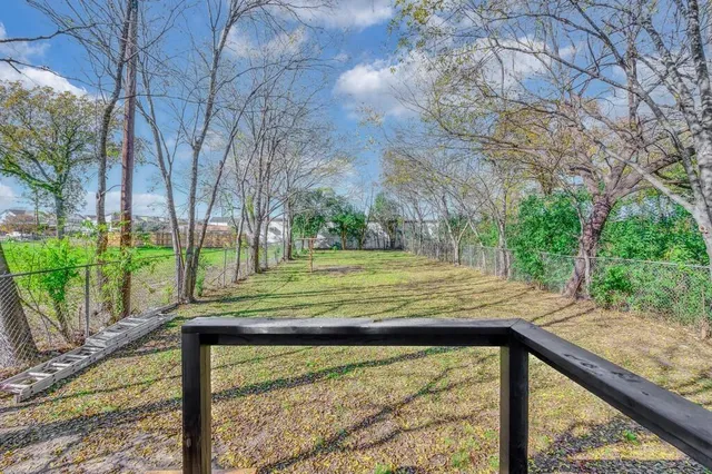 a view of a yard with wooden fence