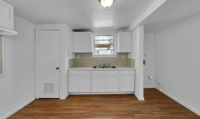 a kitchen with granite countertop white cabinets and a sink