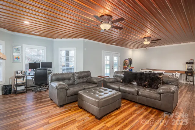 a kitchen with stainless steel appliances kitchen island granite countertop a table chairs refrigerator and microwave