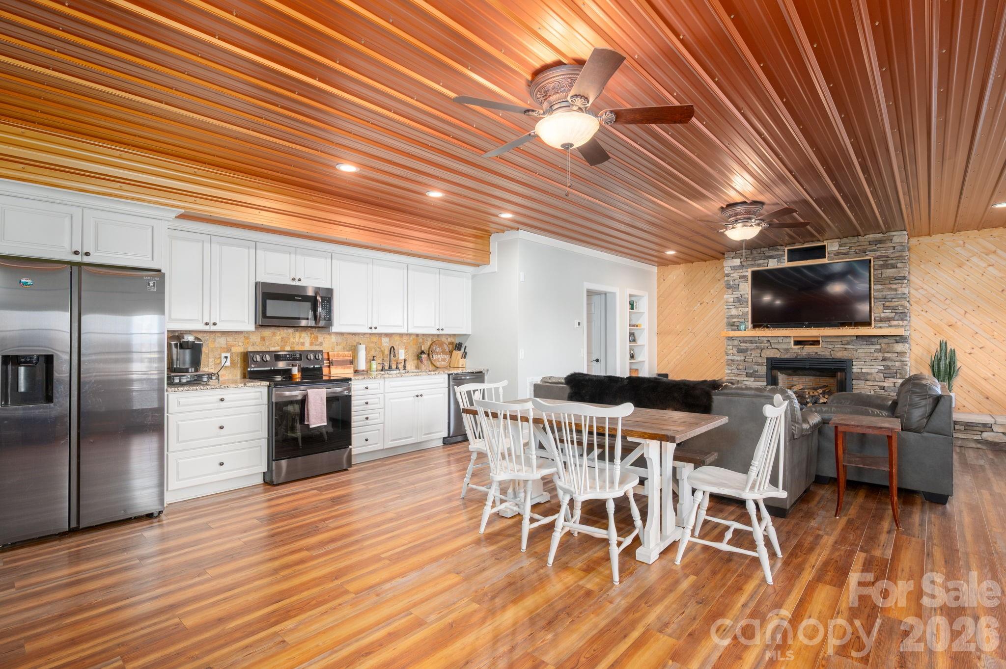 2616 Nicklaus Court Conover, NC 28613 - Photo 25 of 48 a kitchen with stainless steel appliances kitchen island granite countertop a table chairs refrigerator and microwave