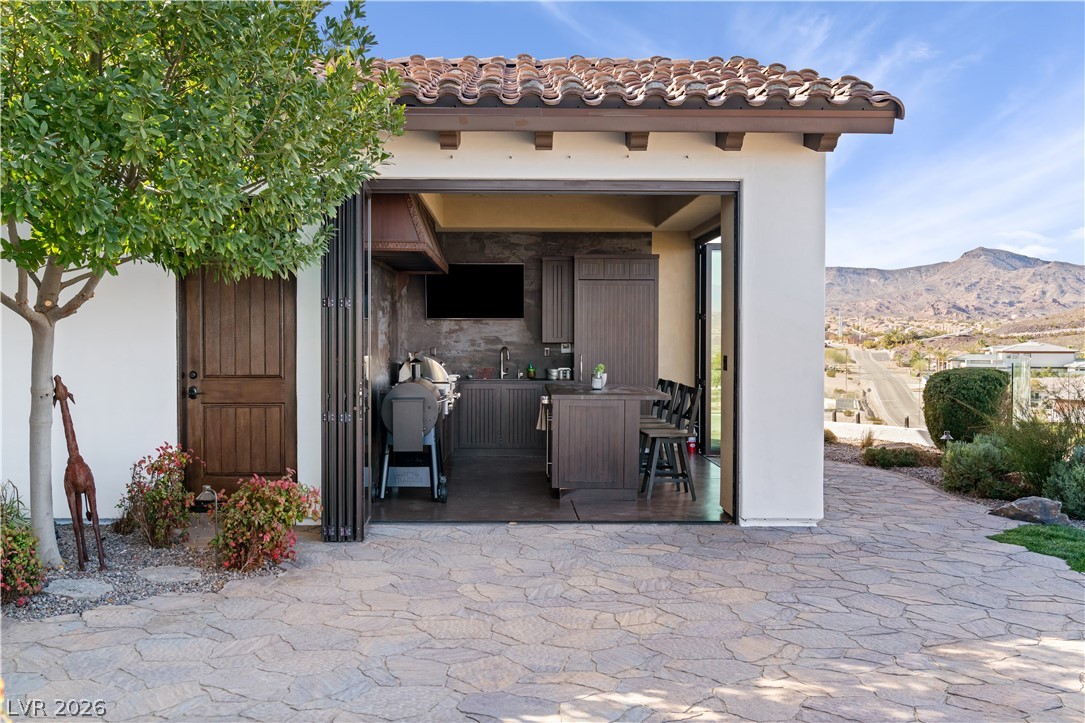 1123 Christian Road Henderson, NV 89002 - Photo 51 of 94 An outdoor kitchen with accordion doors opens to desert mountain views.