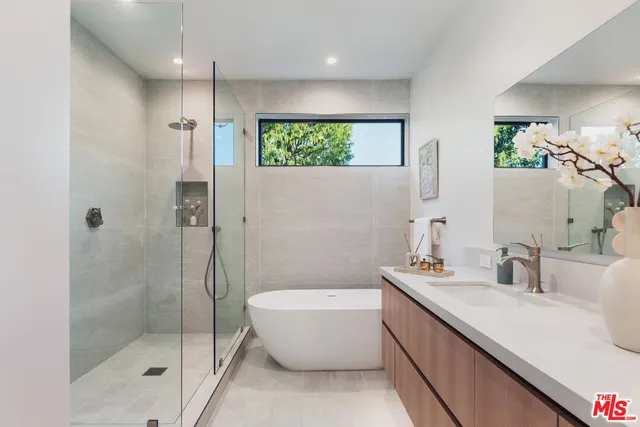 a bathroom with a tub a sink and mirror