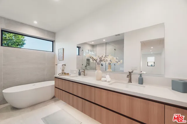 a bathroom with a double vanity sink mirror and bathtub