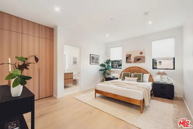 a bedroom with a bed potted plant with the view of bathroom