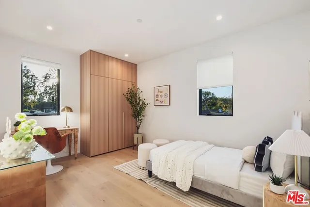 a bedroom with a bed table and a window