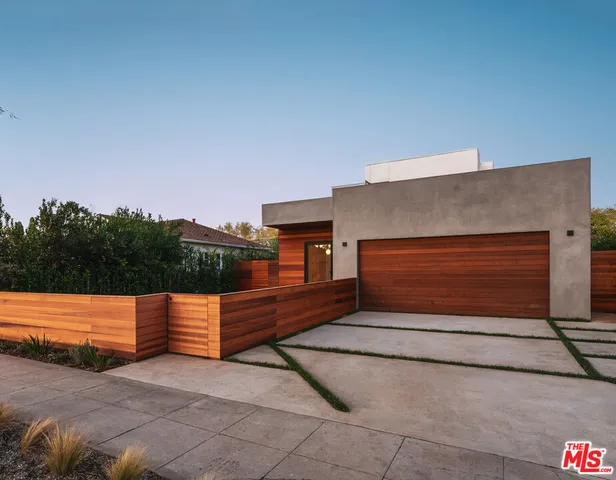 a backyard of a house with wooden fence and trees