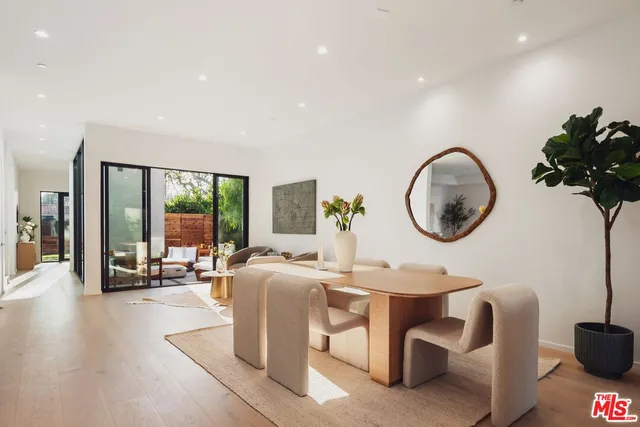 a living room with furniture a mirror and a large window