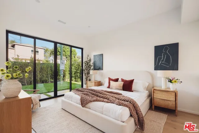 a bedroom with a bed and a large window