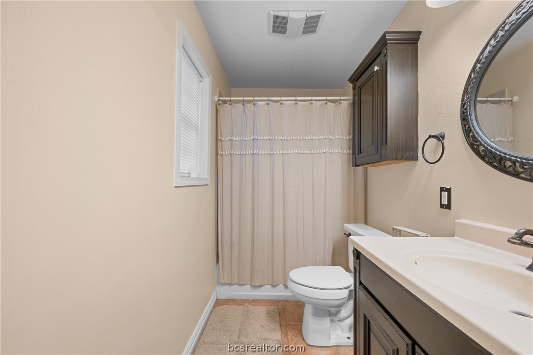 3540 Fisher Ranch Road Bryan, TX 77808 - Photo 14 of 36 a bathroom with a sink a toilet and a mirror