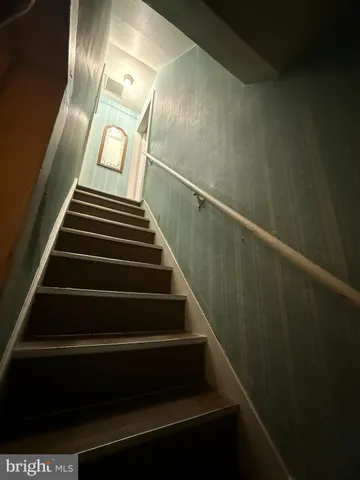 a bed sitting in a bedroom next to a window with rug