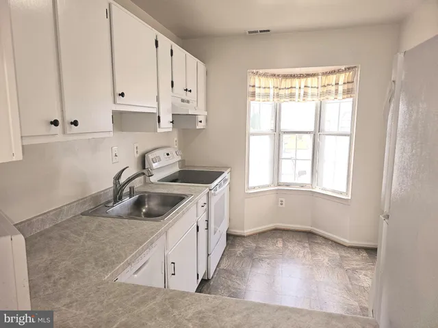 a kitchen with sink cabinets and window
