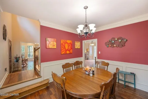 a view of a dining room with furniture a chandelier and wooden floor