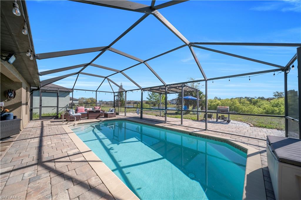 175 Shadowview Court Lehigh Acres, FL 33974 - Photo 9 of 39 Outdoor pool featuring a lanai, a sunroom, a patio, and outdoor furniture