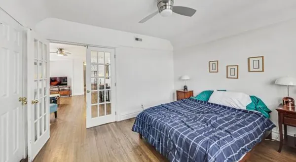 a bedroom with a bed and a wooden floor