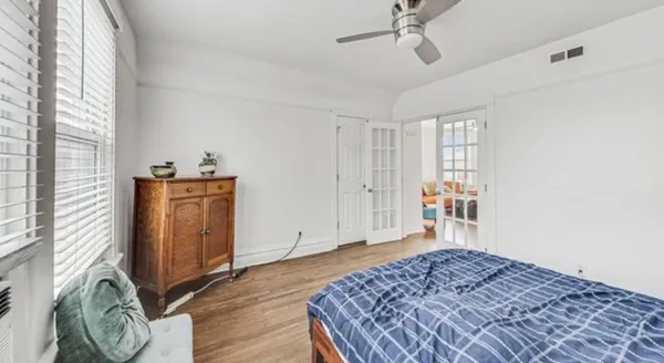a bedroom with a bed and wooden floor
