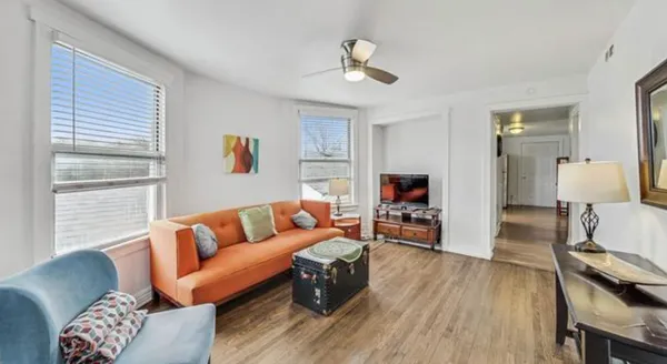 a living room with furniture and a wooden floor