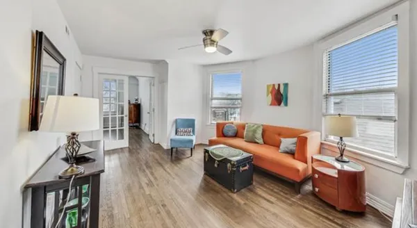 a living room with furniture and a wooden floor