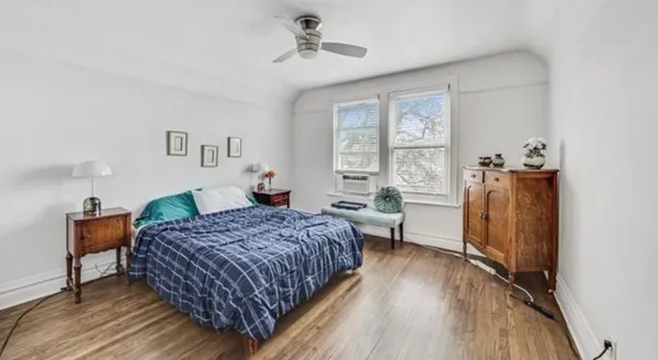 a bedroom with a bed and wooden floor
