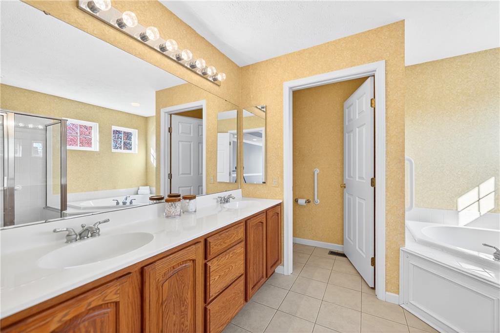 809 Wible Run Road Pittsburgh, PA 15209 - Photo 22 of 36 a bathroom with a granite countertop double vanity sink a mirror and a bathtub