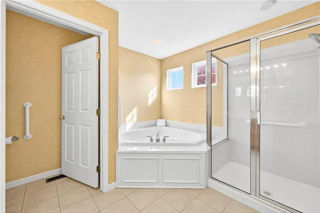 a bathroom with a bathtub shower sink and mirror