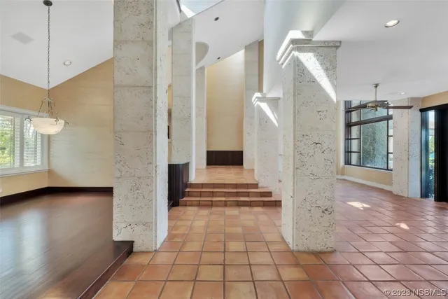a view of a hallway with wooden floor and a living room