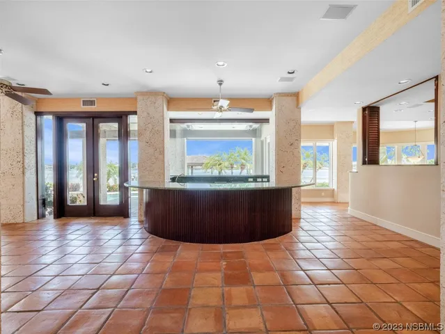 a large white kitchen with a large island oven a stove a dining table and chairs