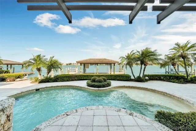 an aerial view of a house with outdoor space and lake view in back