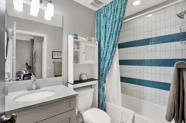 a bathroom with a sink a toilet a mirror and shower