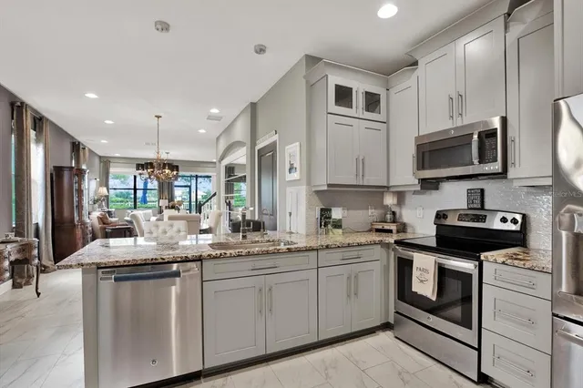 a kitchen with stainless steel appliances granite countertop a sink stove oven a microwave and cabinets