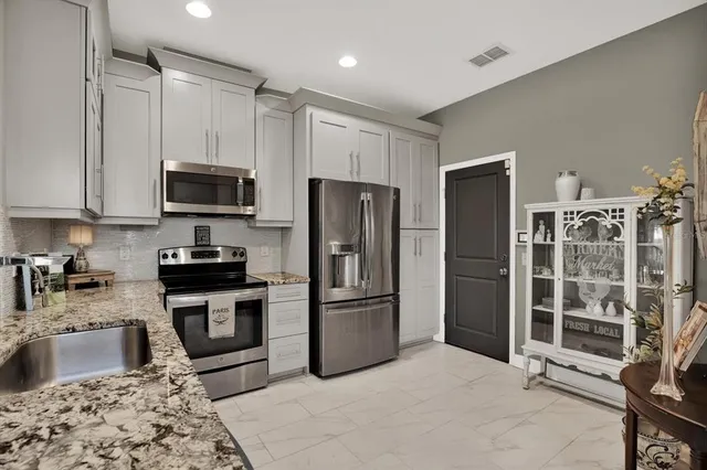 a kitchen with stainless steel appliances granite countertop a refrigerator a stove a sink and a granite counter tops