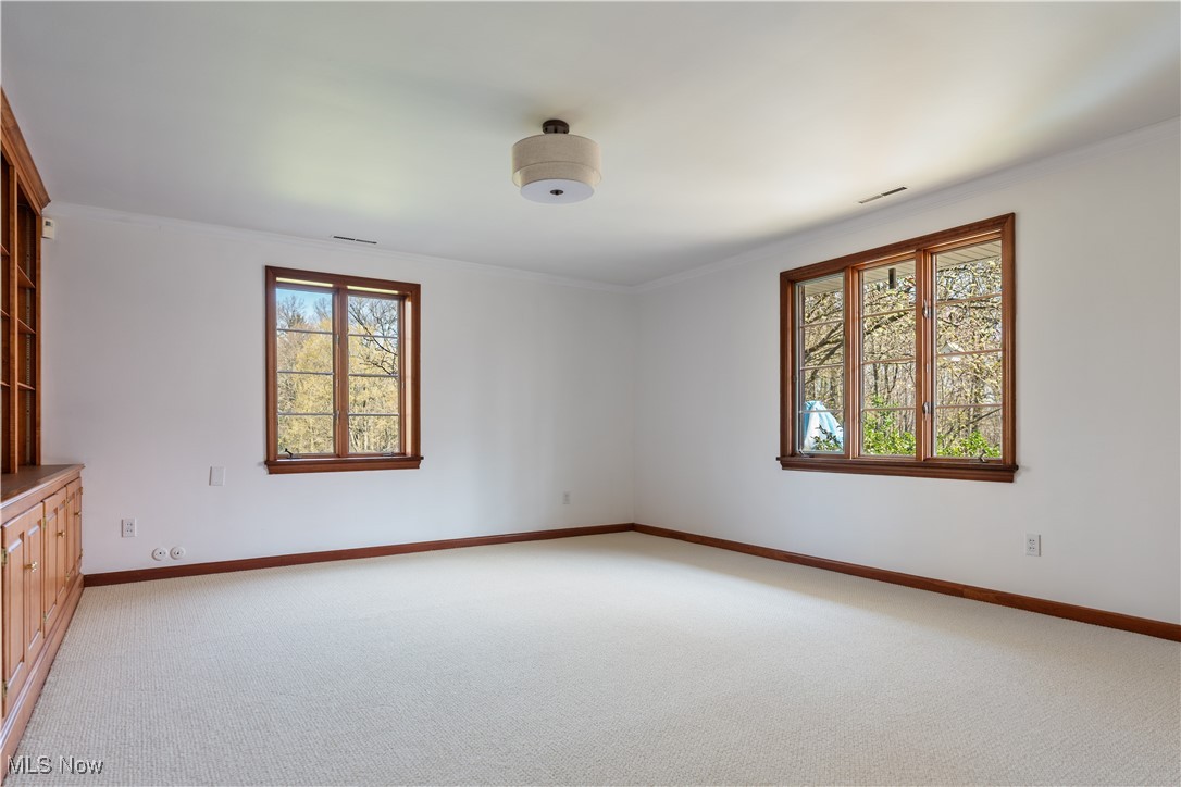 2622 Glenmont Road Northwest Canton, OH 44708 - Photo 33 of 45 Empty room featuring light colored carpet, baseboards, crown molding, and visible vents