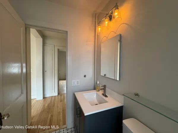 a bathroom with a sink toilet and mirror